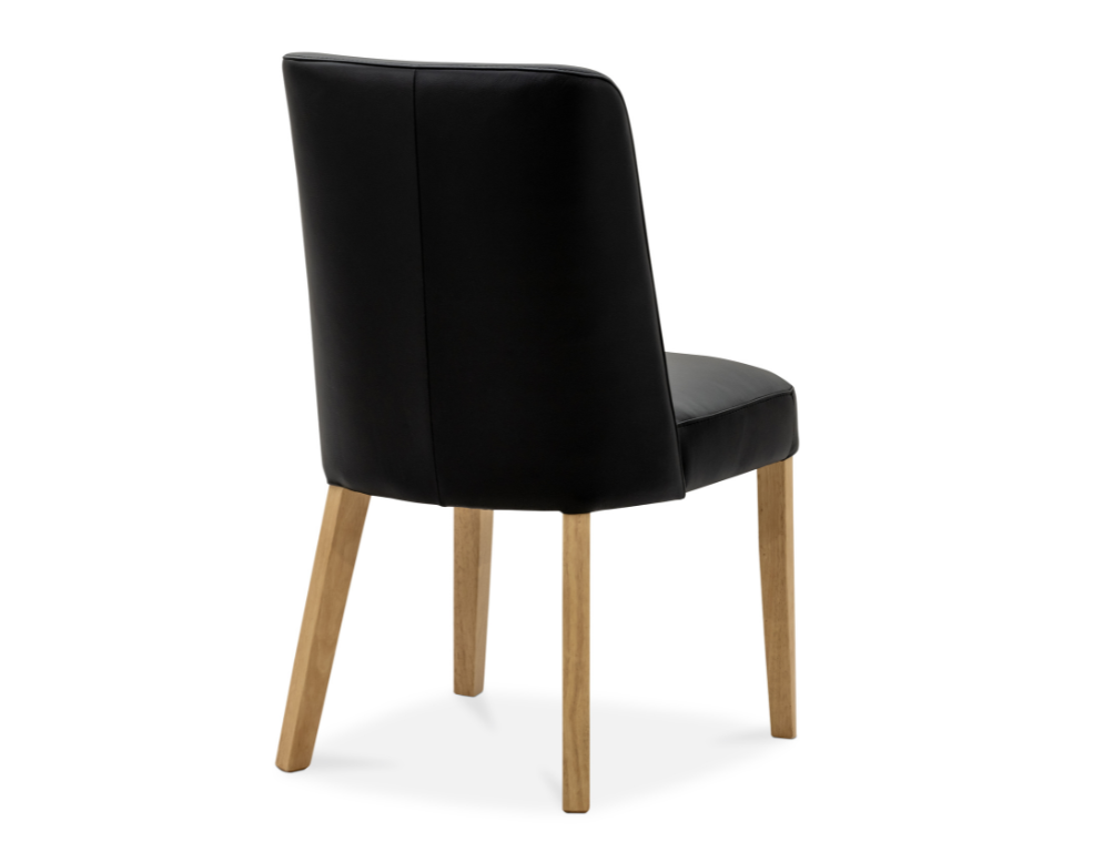 Black leather upholstered chair with oak legs on a white background from back view